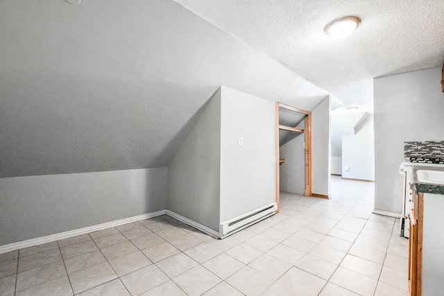 3339 Aldrich Ave N, Minneapolis, MN 55412 - additional living space featuring vaulted ceiling, a textured ceiling, a baseboard radiator, and light tile patterned floors