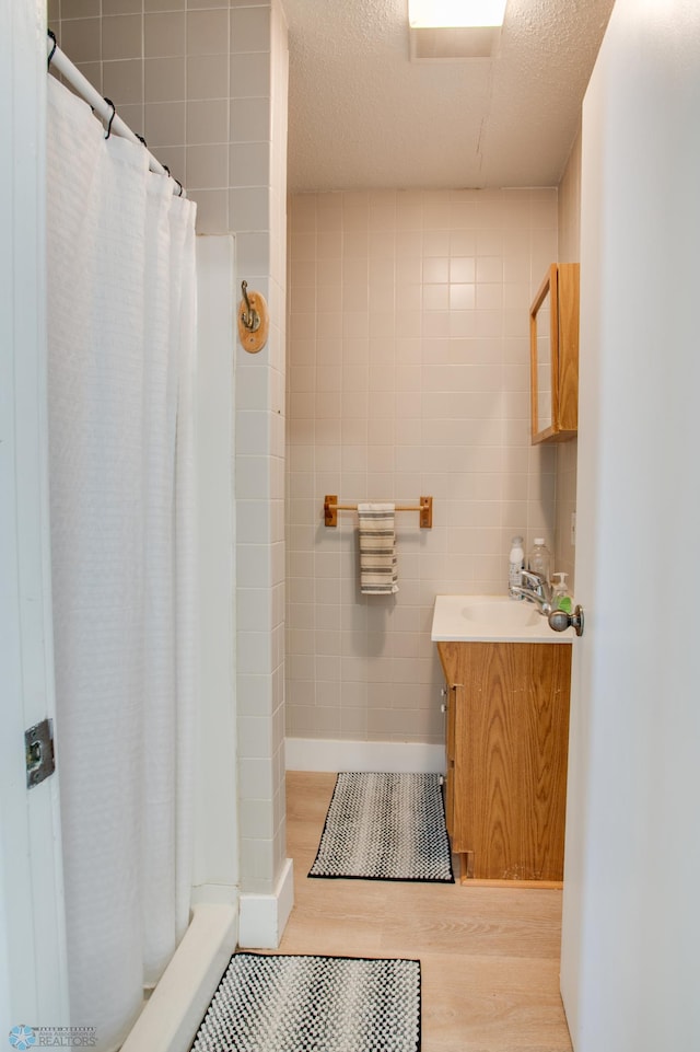 1137 11th St N, Fargo, ND 58102 - bathroom with wood finished floors, vanity, a shower with curtain, and a textured ceiling