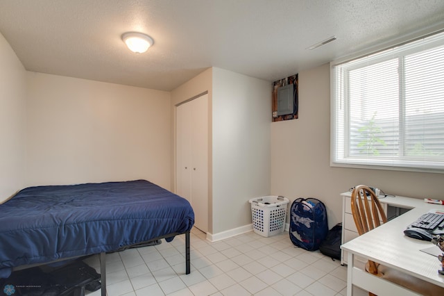 1137 11th St N, Fargo, ND 58102 - bedroom with electric panel, light tile patterned floors, and a textured ceiling