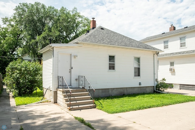 1137 11th St N, Fargo, ND 58102 - view of front of home featuring roof with shingles, a front yard, and a chimney