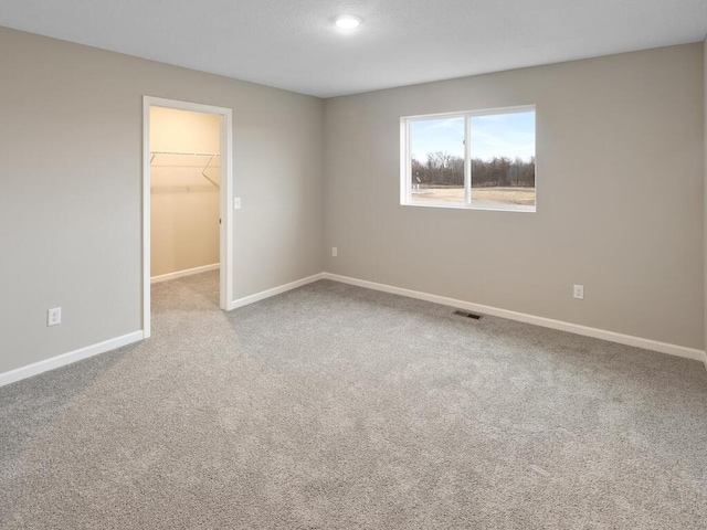 6711 Granby St, North Branch, MN 55056 - unfurnished bedroom with a walk in closet and carpet flooring