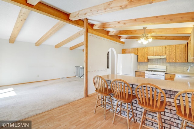 5733 Riverview Entry, Champlin, MN 55316 - kitchen with white appliances, under cabinet range hood, decorative backsplash, beam ceiling, and light countertops