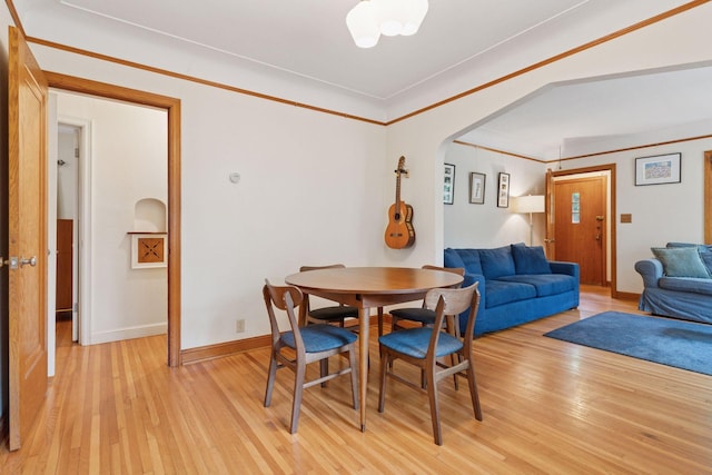 3607 Sheridan Ave N, Minneapolis, MN 55412 - dining space with arched walkways, light wood-style flooring, and crown molding