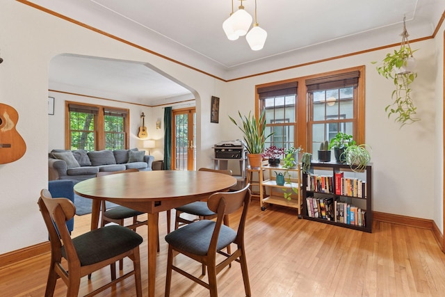 3607 Sheridan Ave N, Minneapolis, MN 55412 - dining space featuring arched walkways, light wood finished floors, and crown molding