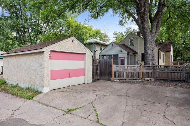3607 Sheridan Ave N, Minneapolis, MN 55412 - view of front facade with a garage, an outdoor structure, driveway, and stucco siding