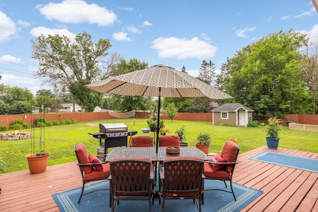 6700 168th St W, Lakeville, MN 55068 - wooden terrace featuring a grill, an outdoor fire pit, outdoor dining space, a fenced backyard, and an outbuilding