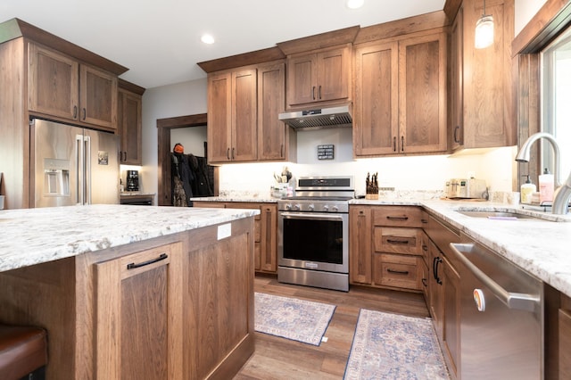 7170 29th Ave SW, Pequot Lakes, MN 56472 - kitchen with appliances with stainless steel finishes, under cabinet range hood, dark wood-style flooring, light stone counters, and recessed lighting