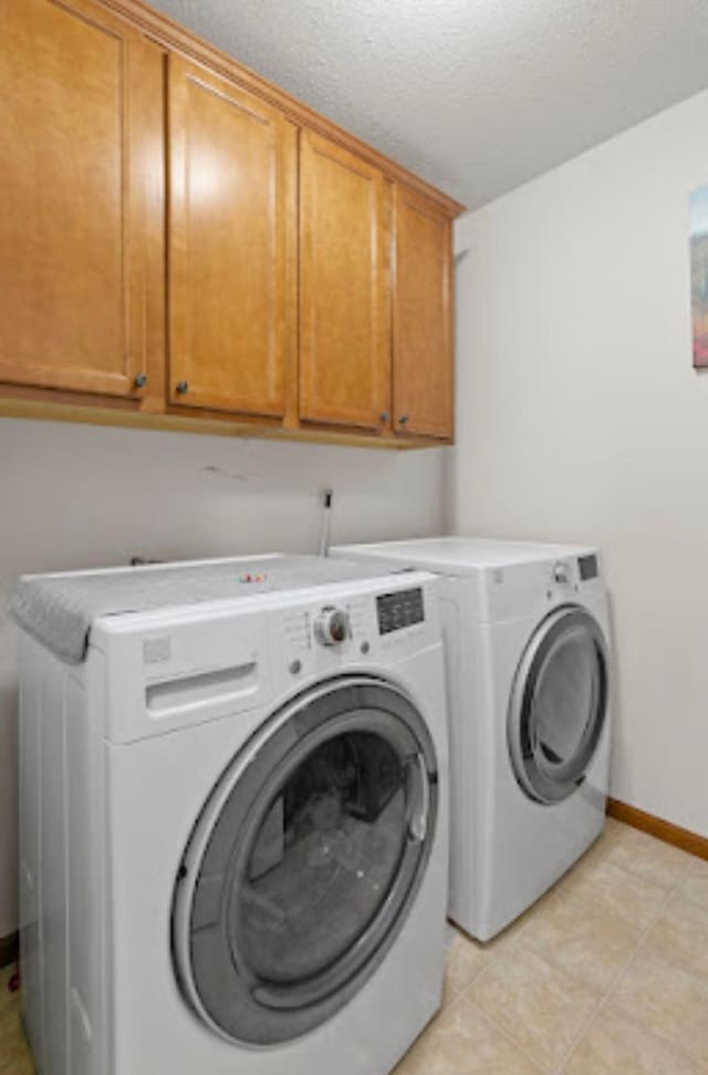 15850 Elmwood Ln, Apple Valley, MN 55124 - washroom featuring cabinet space, washing machine and dryer, a textured ceiling, and light tile patterned floors