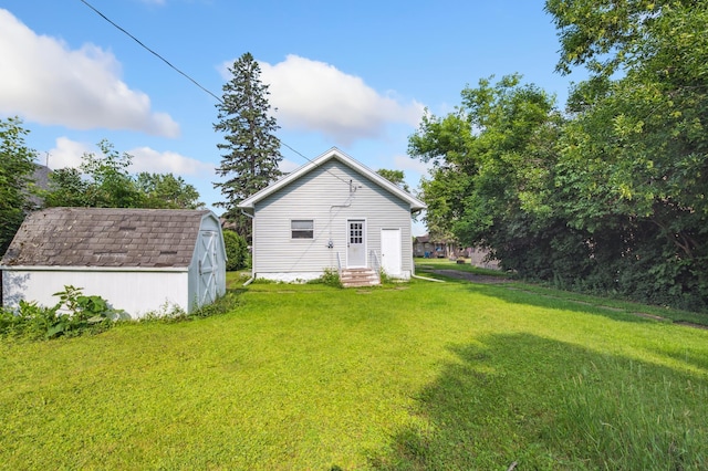 14 15th St, Cloquet, MN 55720 - back of property featuring a storage unit, entry steps, and a lawn