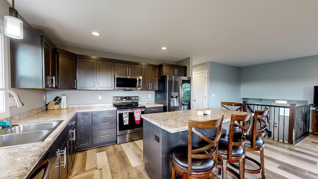 1280 Lone Stone Ct SE, Chatfield, MN 55923 - kitchen featuring appliances with stainless steel finishes, light wood-style flooring, a center island, dark brown cabinets, and light countertops