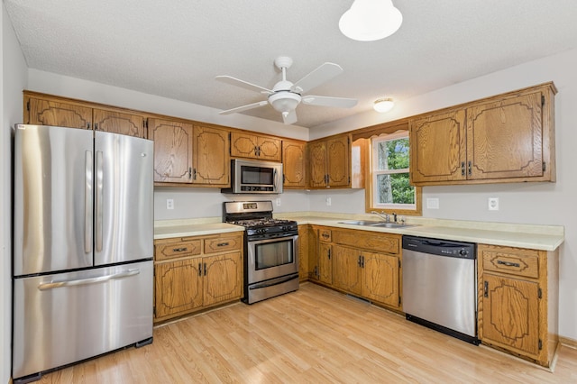 11716 54th St NE, Albertville, MN 55301 - kitchen featuring stainless steel appliances, brown cabinets, light wood-type flooring, and light countertops