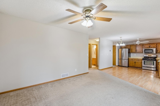 11716 54th St NE, Albertville, MN 55301 - unfurnished living room with light carpet, ceiling fan, and a chandelier