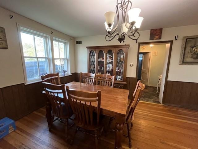102 4th St S, Grove City, MN 56243 - dining room with a wainscoted wall, wood-type flooring, a chandelier, and wood walls