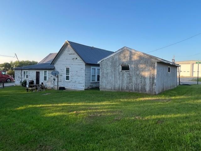 102 4th St S, Grove City, MN 56243 - back of house featuring a yard and a metal roof