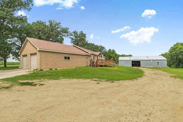 43054 105th Ave, Brockway Twp, MN 56367 - view of side of home with a lawn, a wooden deck, brick siding, and driveway