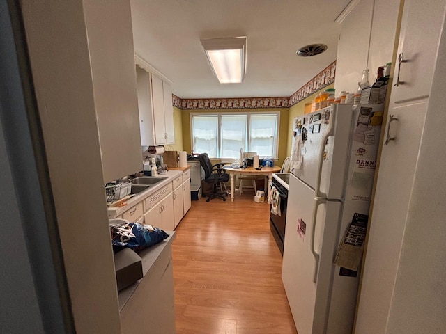 7145 Nicollet Ave S, Richfield, MN 55423 - kitchen with freestanding refrigerator, white cabinets, a desk, light wood-style flooring, and black range with electric cooktop