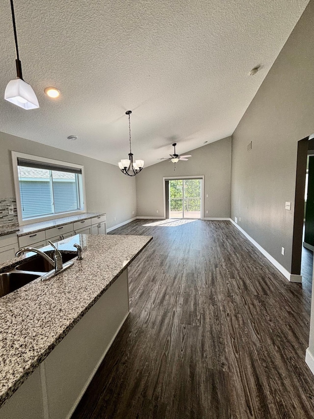 2032 Reuss Pkwy, Saint Croix Falls, WI 54024 - kitchen with dark wood-style flooring, white cabinetry, a textured ceiling, pendant lighting, and vaulted ceiling