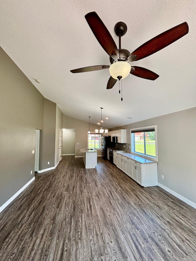 2032 Reuss Pkwy, Saint Croix Falls, WI 54024 - unfurnished living room with a ceiling fan, dark wood-style floors, a textured ceiling, and vaulted ceiling