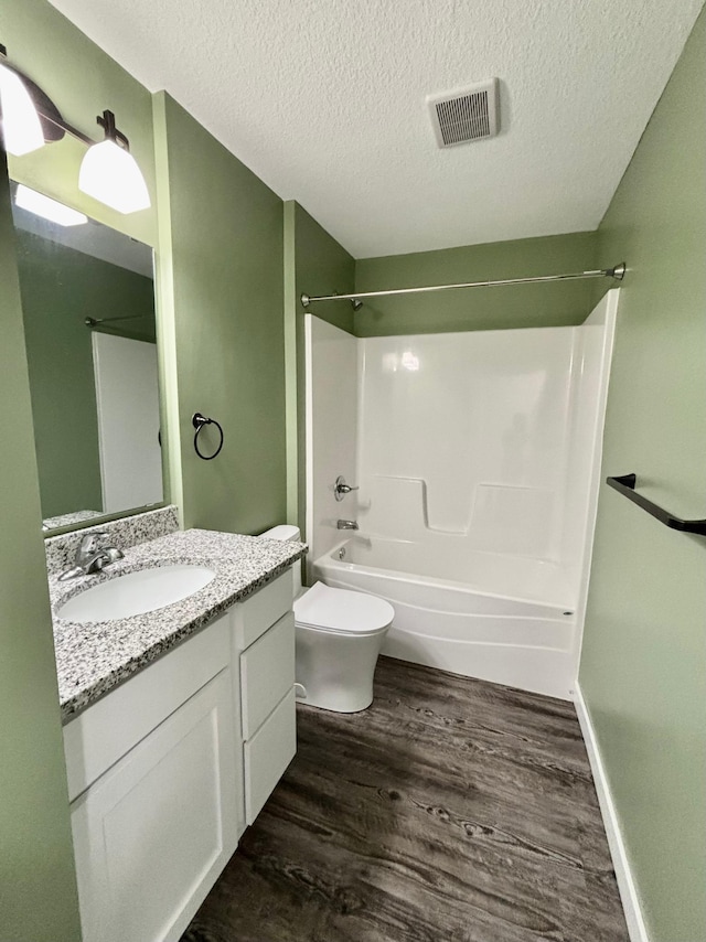 2032 Reuss Pkwy, Saint Croix Falls, WI 54024 - bathroom featuring wood finished floors, vanity, a textured ceiling, and washtub / shower combination