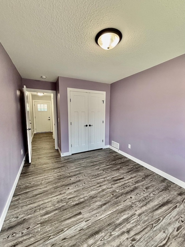 2032 Reuss Pkwy, Saint Croix Falls, WI 54024 - unfurnished bedroom with dark wood finished floors, a closet, and a textured ceiling