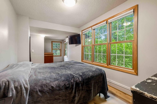 12639 65th Ave SW, May Twp, MN 56466 - bedroom with a textured ceiling, wood finished floors, and baseboard heating