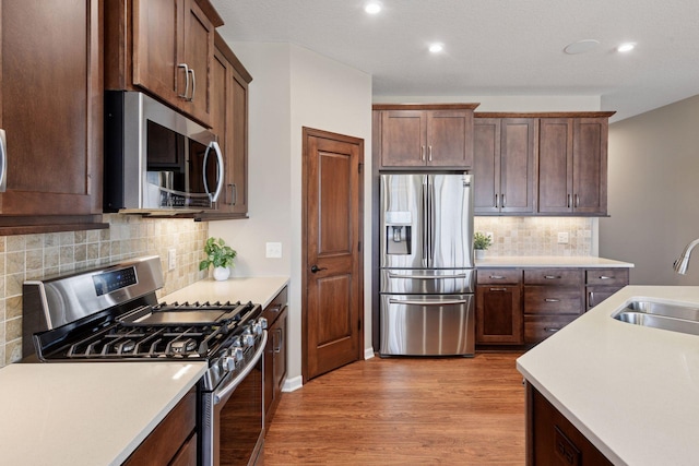 7461 Fir Ln N, Corcoran, MN 55340 - kitchen with appliances with stainless steel finishes, light countertops, light wood-style floors, and recessed lighting