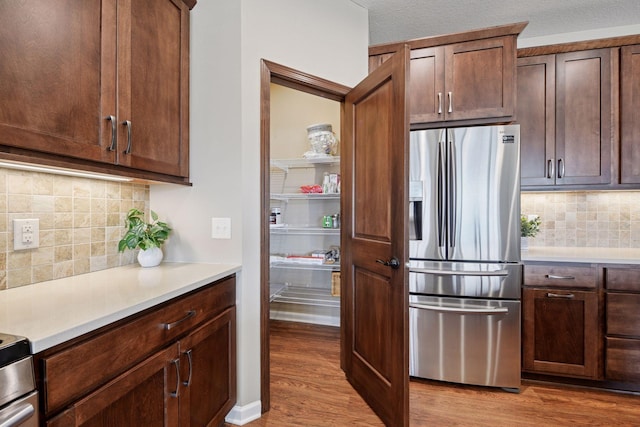 7461 Fir Ln N, Corcoran, MN 55340 - kitchen with stainless steel fridge with ice dispenser, light wood-style flooring, tasteful backsplash, light countertops, and dark brown cabinetry