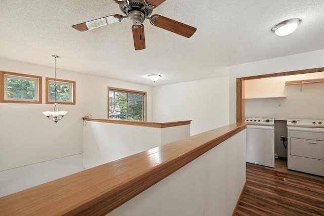 5460 100th Ln N, Brooklyn Park, MN 55443 - hallway featuring separate washer and dryer, a chandelier, dark wood-style floors, a textured ceiling, and an upstairs landing