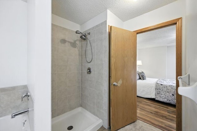 5460 100th Ln N, Brooklyn Park, MN 55443 - full bath with ensuite bath, a textured ceiling, tiled shower, and wood finished floors