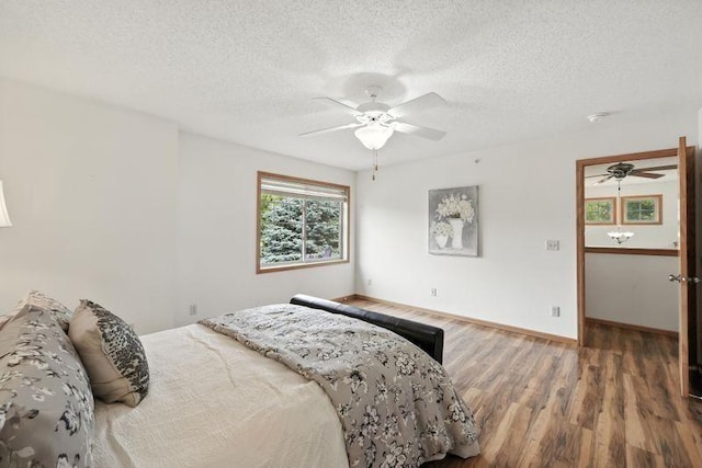 5460 100th Ln N, Brooklyn Park, MN 55443 - bedroom featuring wood finished floors, a textured ceiling, and ceiling fan