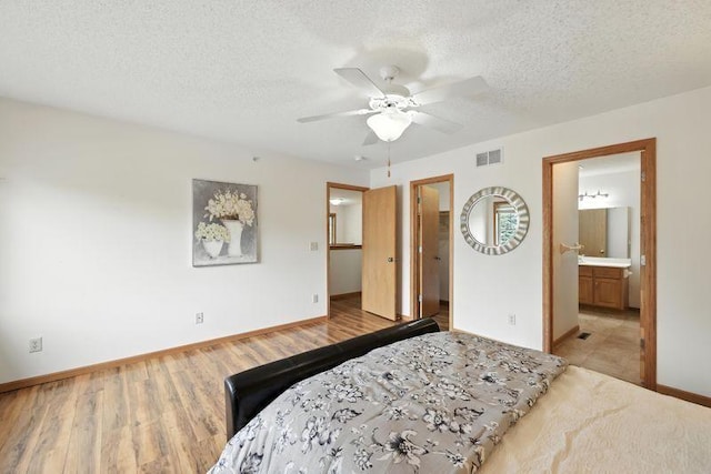 5460 100th Ln N, Brooklyn Park, MN 55443 - bedroom with a spacious closet, a textured ceiling, wood finished floors, ensuite bathroom, and a ceiling fan