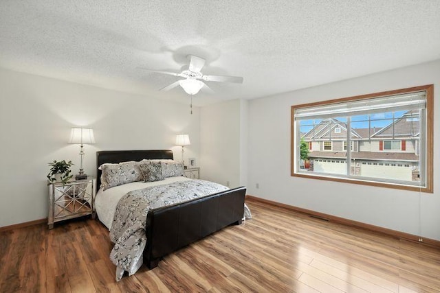 5460 100th Ln N, Brooklyn Park, MN 55443 - bedroom with wood finished floors, a textured ceiling, and ceiling fan