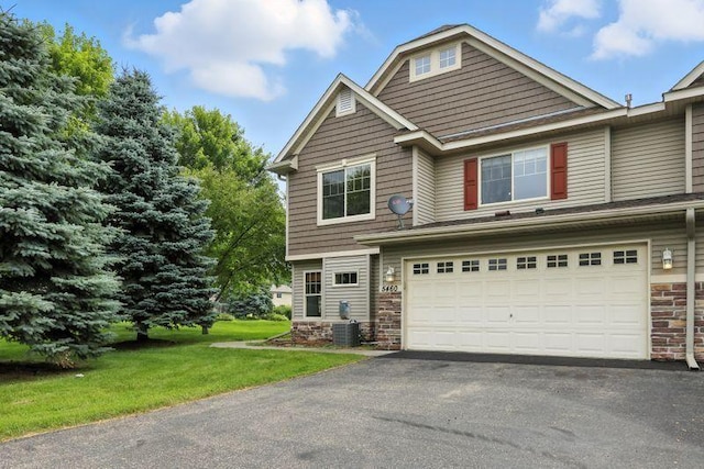 5460 100th Ln N, Brooklyn Park, MN 55443 - craftsman house with stone siding, a garage, asphalt driveway, and a front yard