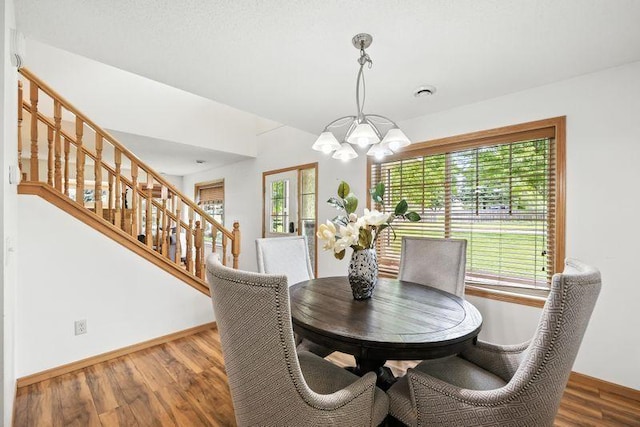 5460 100th Ln N, Brooklyn Park, MN 55443 - dining area with a chandelier, wood finished floors, and stairway