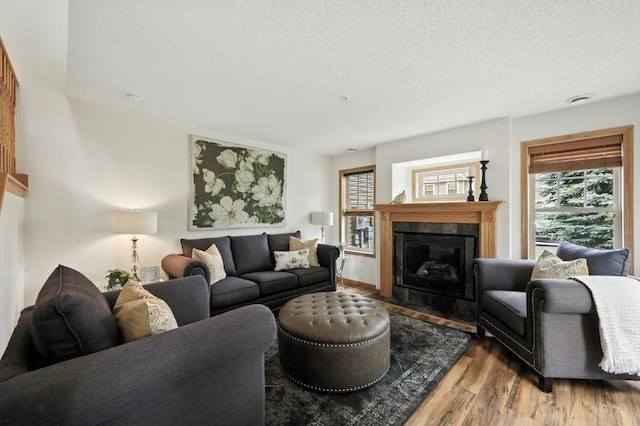 5460 100th Ln N, Brooklyn Park, MN 55443 - living area featuring wood finished floors, plenty of natural light, a fireplace with flush hearth, and a textured ceiling
