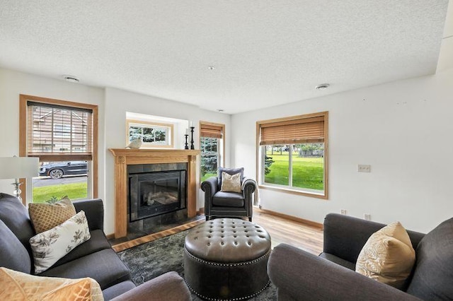 5460 100th Ln N, Brooklyn Park, MN 55443 - living room featuring a textured ceiling, wood finished floors, healthy amount of natural light, and a tiled fireplace