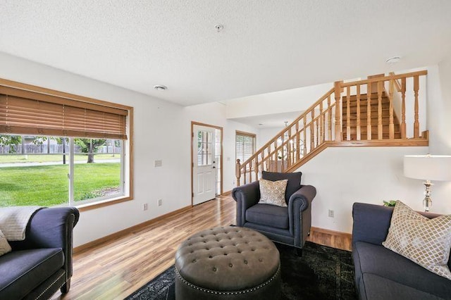 5460 100th Ln N, Brooklyn Park, MN 55443 - living area with stairway, wood finished floors, and a textured ceiling