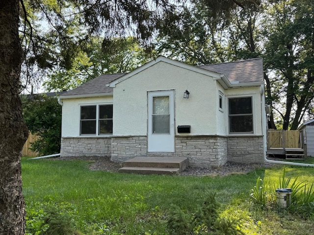 33858 Hastings St NE, Cambridge Twp, MN 55008 - back of property featuring stone siding, a shingled roof, and a lawn