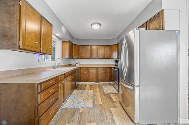 44042 Outlet Beach Rd, Lida Twp, MN 56572 - kitchen with stainless steel appliances, light wood-type flooring, brown cabinetry, and light countertops
