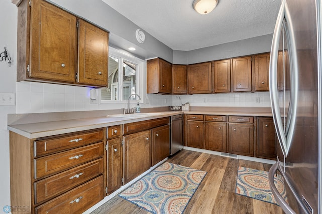 44042 Outlet Beach Rd, Lida Twp, MN 56572 - kitchen featuring appliances with stainless steel finishes, dark wood-style floors, brown cabinetry, light countertops, and a textured ceiling