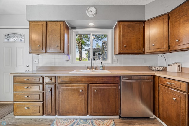 44042 Outlet Beach Rd, Lida Twp, MN 56572 - kitchen featuring stainless steel dishwasher, wood finished floors, brown cabinets, and tasteful backsplash