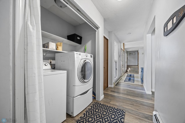 44042 Outlet Beach Rd, Lida Twp, MN 56572 - laundry area featuring washer and clothes dryer, wood finished floors, a baseboard radiator, and a textured ceiling
