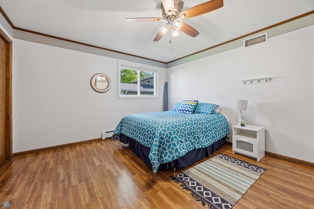 44042 Outlet Beach Rd, Lida Twp, MN 56572 - bedroom featuring ornamental molding, a textured ceiling, wood finished floors, a baseboard radiator, and ceiling fan
