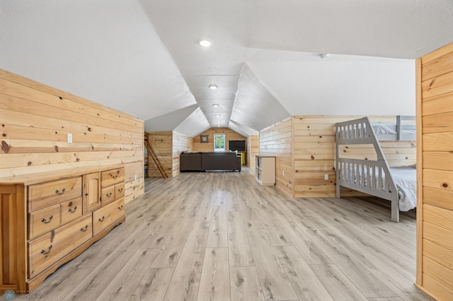 44042 Outlet Beach Rd, Lida Twp, MN 56572 - unfurnished bedroom featuring wood walls, lofted ceiling, and light wood-style flooring