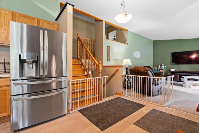 10919 Eagle St NW, Coon Rapids, MN 55433 - kitchen with stainless steel fridge with ice dispenser, open floor plan, light wood-style flooring, and decorative light fixtures
