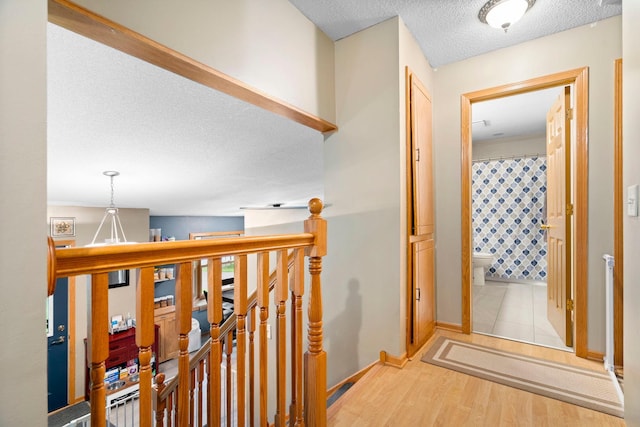 10919 Eagle St NW, Coon Rapids, MN 55433 - corridor with a textured ceiling, an upstairs landing, and light wood-style floors