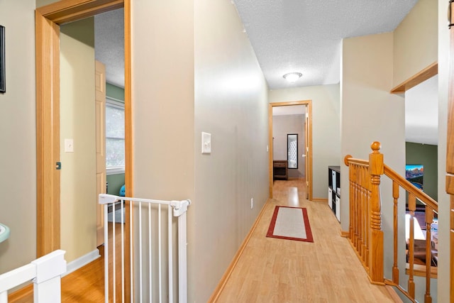 10919 Eagle St NW, Coon Rapids, MN 55433 - hall featuring an upstairs landing, light wood-style floors, and a textured ceiling