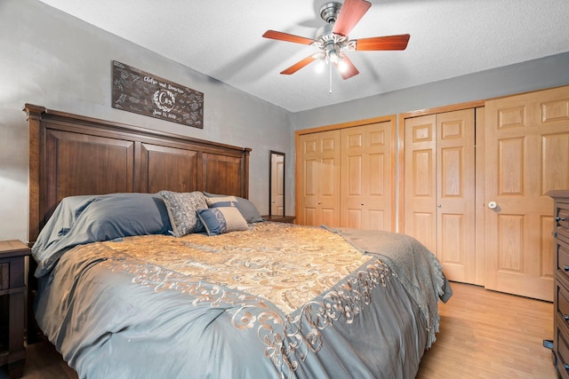 10919 Eagle St NW, Coon Rapids, MN 55433 - bedroom with two closets, light wood-style flooring, a ceiling fan, and a textured ceiling