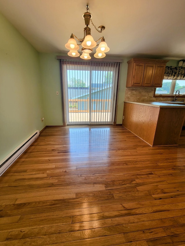 619 3rd St NW, Forest Lake, MN 55025 - kitchen featuring a chandelier, dark wood-style flooring, healthy amount of natural light, and a peninsula