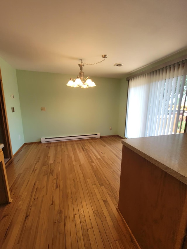 619 3rd St NW, Forest Lake, MN 55025 - unfurnished room featuring a baseboard heating unit, a chandelier, and light wood-type flooring